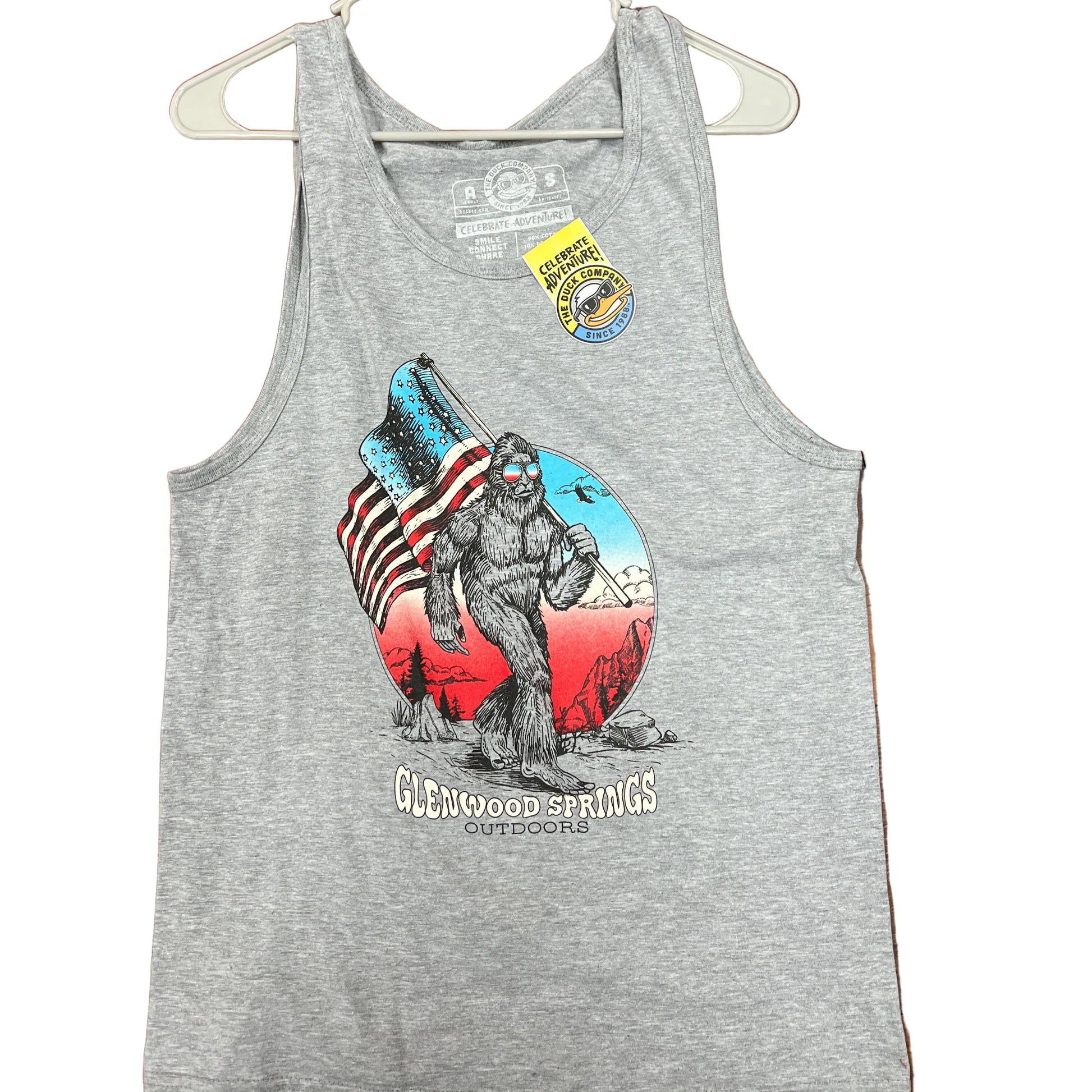 Gray tank top with graphic design on a wooden floor