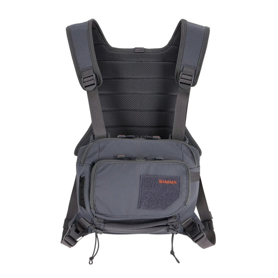 Simms Tributary Chest Pack — front and back view showing mesh harness, adjustable straps, and main storage compartment in carbon colorway